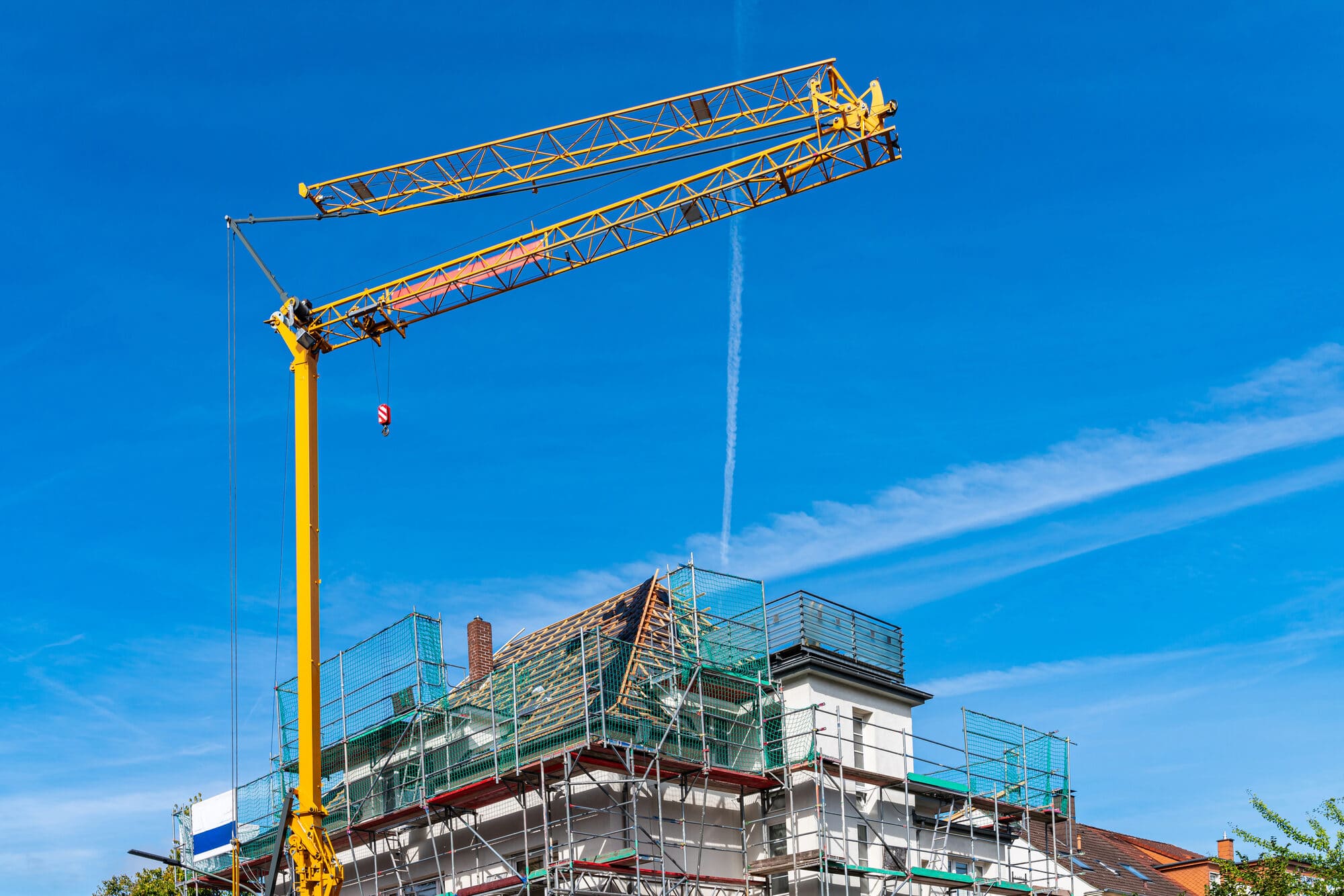 Wohnbauprojekt im Bau mit Kran und Gerüst